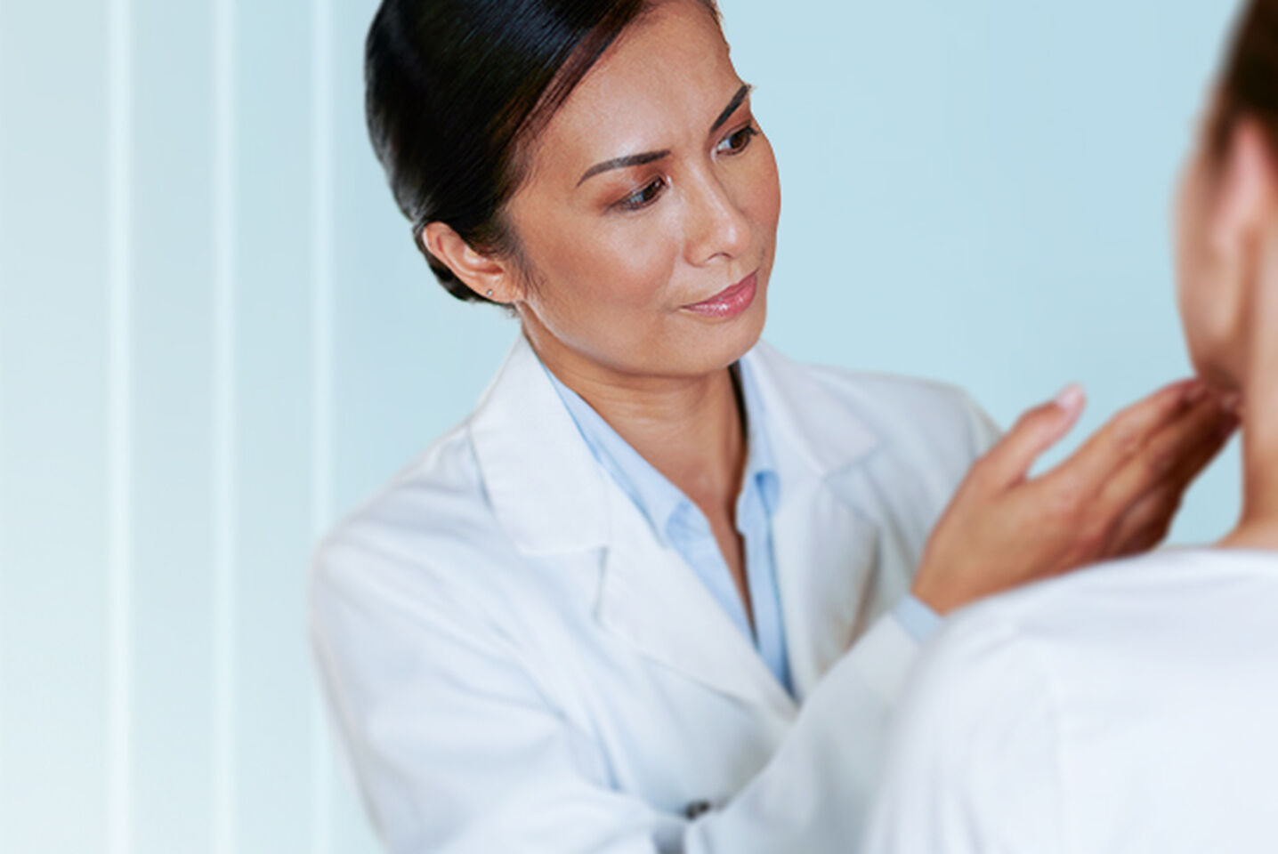 Dermatologist examining a patient’s skin with Cetaphil skincare care focus.