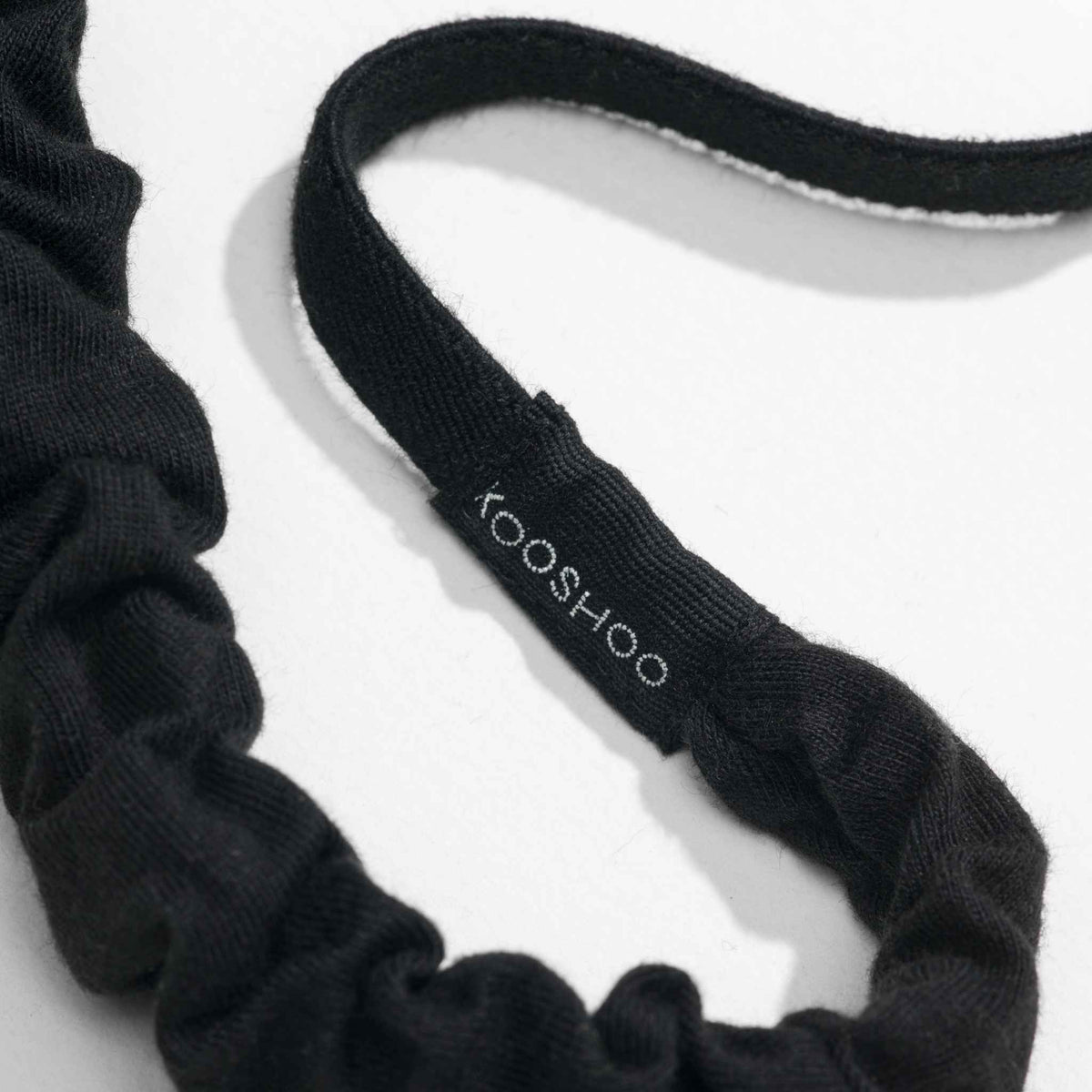 Black organic cotton and natural rubber elastic scrunchie headband with 'kooshoo' branding on a white background
#color_black