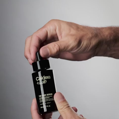 Applying Caldera Lab The Hair Serum with dropper showing texture and targeted application